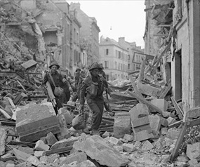 Capturing Caen: British soldiers trudge through rubble
