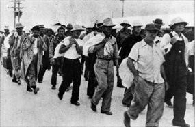 U.S. military and civilian prisoners march to Japanese transport ship, January 12, 1942